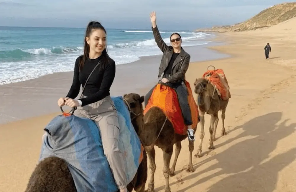 Cap sur la côte Deux femmes suivent un circuit en dromadaire sur la plage d’Essaouira