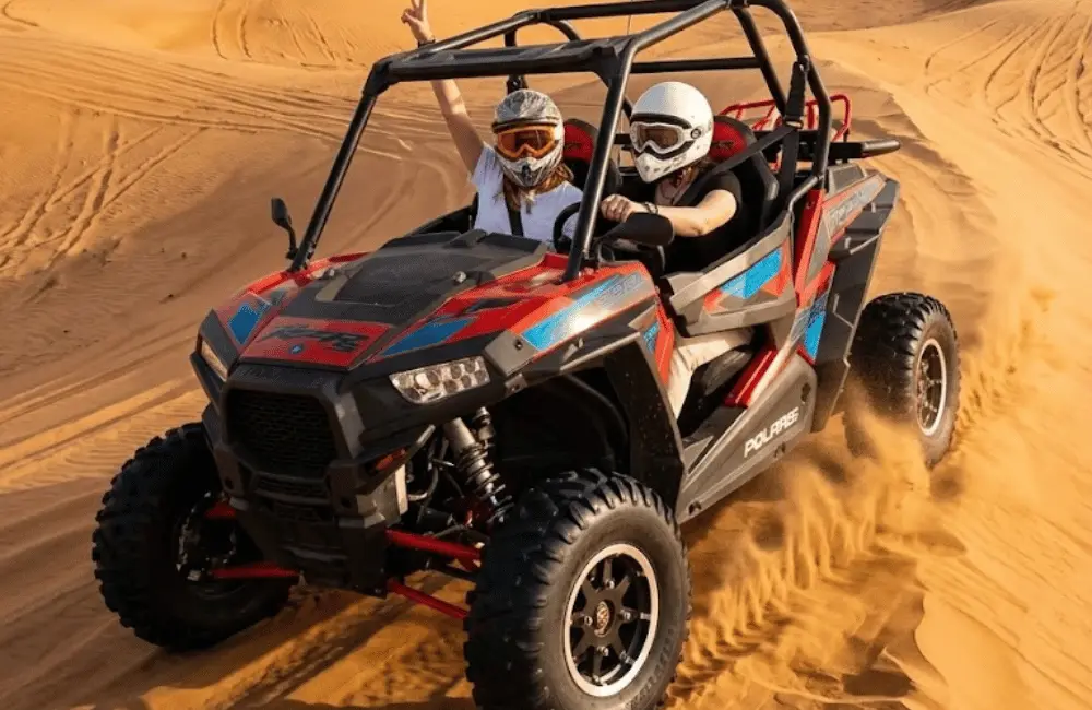 Buggy biplace avec deux participants casqués sur les dunes pendant une excursion guidée à Essaouira