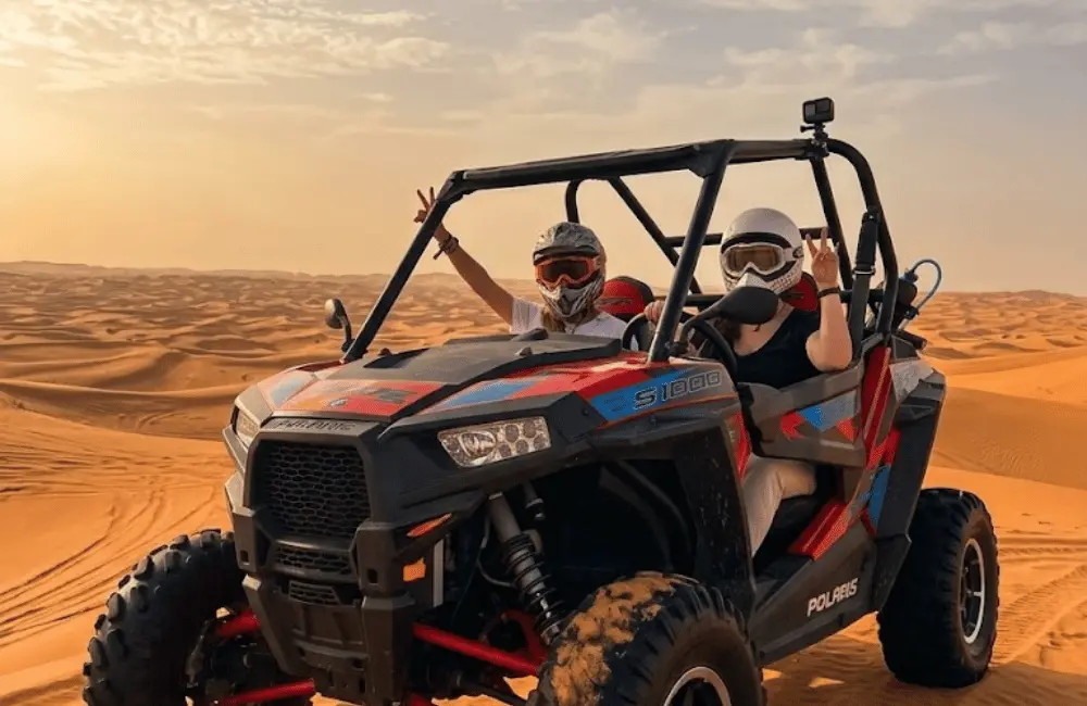 Couple en buggy biplace dans les dunes au coucher du soleil lors d’une sortie à Essaouira