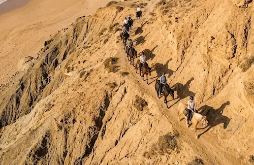 Famille avec enfants profitant d'une balade à cheval encadrée sur la plage d'Essaouira