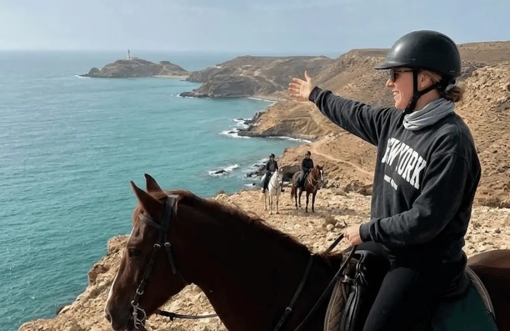 Cavalier à cheval se détachant sur le ciel enflammé du coucher de soleil à Essaouira