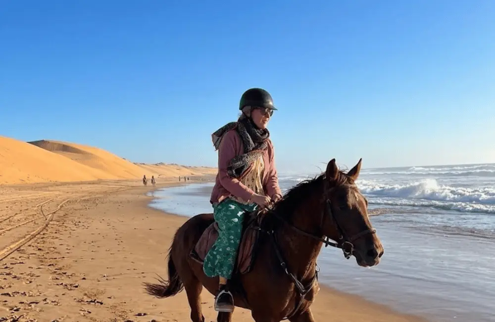 Cavaliers à cheval au bord des vagues sur l'immense plage sauvage d'Essaouira