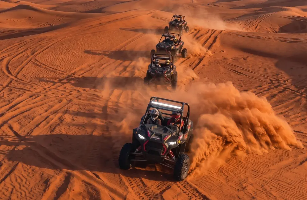 Convoi de buggys roulant dans les dunes de sable