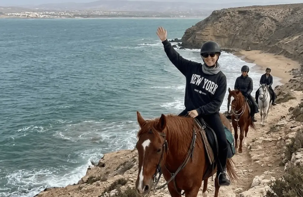 Guide équestre accompagnant un groupe à cheval sur le littoral de Diabat Essaouira
