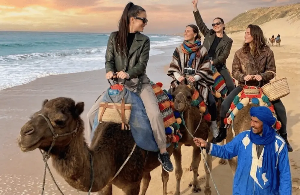 La caravane guidée Groupe accompagné par un guide pendant une balade en dromadaire sur la plage