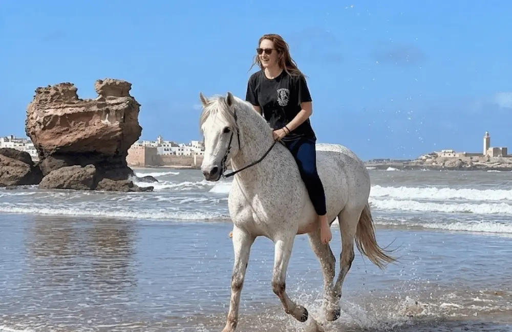 Cavaliers en randonnée à cheval traversant la forêt d'eucalyptus et dunes du Cap Sim