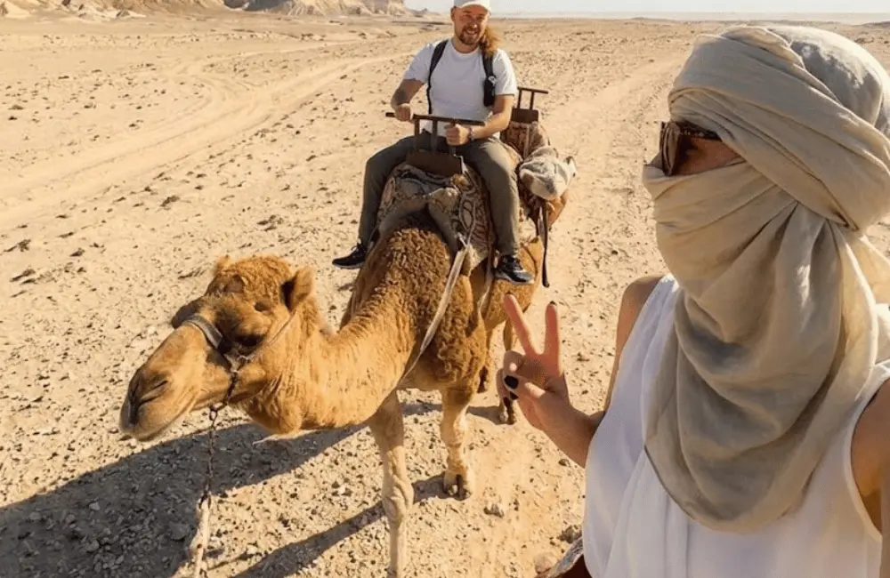 Le souvenir pris en chemin Voyageuse prend un selfie pendant une excursion en dromadaire dans un paysage sableux